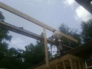 Carpenter setting a ridge beam over a new addition frame — Ice Dam Removal by Roofing Brothers in Roscoe
