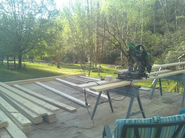 Miter saw and framing lumber on a deck under construction in Roscoe