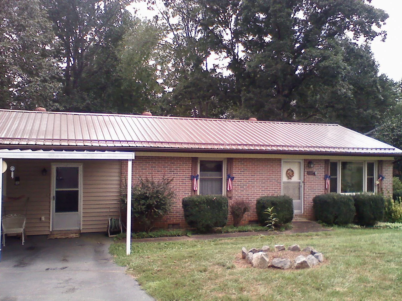 Bronze metal roof and carport on a brick ranch home — Roof Repair work by our crew in Roscoe